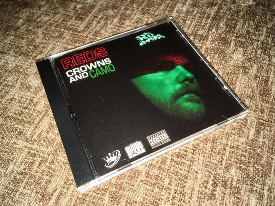 Original Reds Crowns and Camo front cover with a green-lit portrait and dark red cap